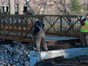 Workers guide the placement of walker johnston bridge.