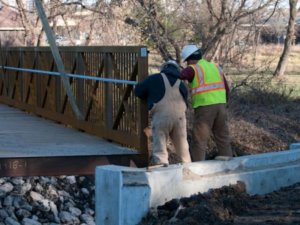 Herberger crew members inspect the Walker Johnston Park bridge.